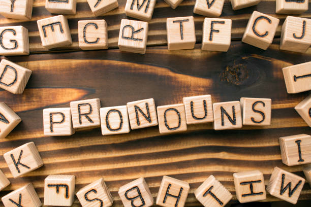 word pronouns composed of wooden cubes with letters word pronouns composed of wooden cubes with letters, Part of speech concept scattered around the cubes random letters, top view on wooden background verb stock pictures, royalty-free photos & images