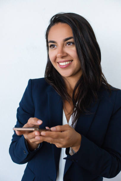 istock Smiling young woman holding mobile phone 1164164648
