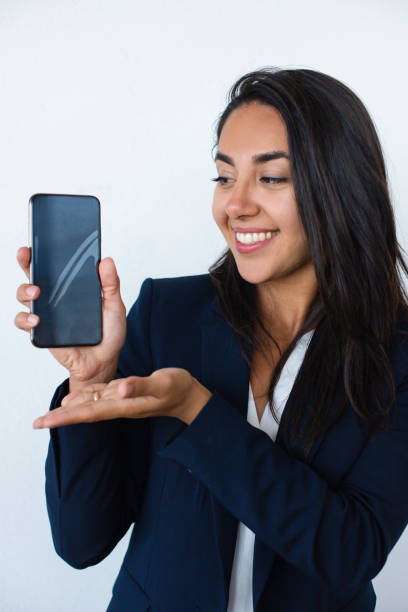 istock Cheerful young woman showing mobile phone 1164165229