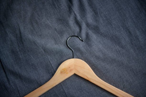 istock Wooden clothes hanger with black background 1164165404