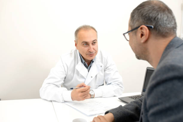 médico urólogo aconseja a un paciente masculino en la clínica - prostate exam fotografías e imágenes de stock