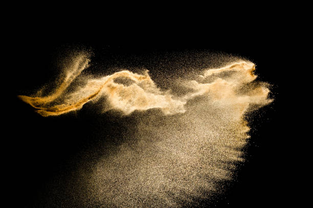 istock Abstract sand cloud.Golden colored sand splash agianst dark background.Yellow sand fly wave in the air. Sand explode on black background ,throwing freeze stop motion concept. 1164167337