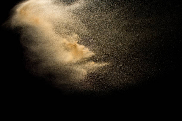 istock Abstract sand cloud.Golden colored sand splash agianst dark background.Yellow sand fly wave in the air. Sand explode on black background ,throwing freeze stop motion concept. 1164167342
