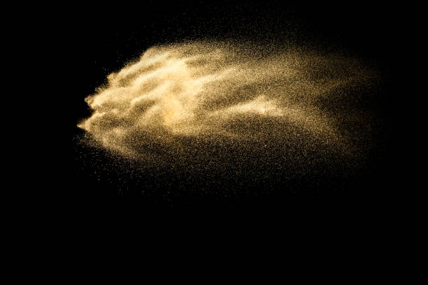 istock Abstract sand cloud.Golden colored sand splash agianst dark background.Yellow sand fly wave in the air. Sand explode on black background ,throwing freeze stop motion concept. 1164167355