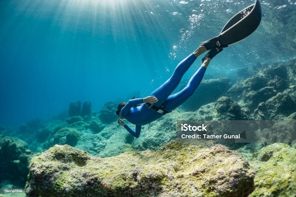 freediver girl in the sea. Diving Into Water Stock Photo