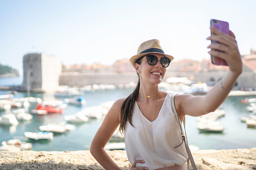 Smiling young woman taking a selfie in Dubrovnik, Croatia