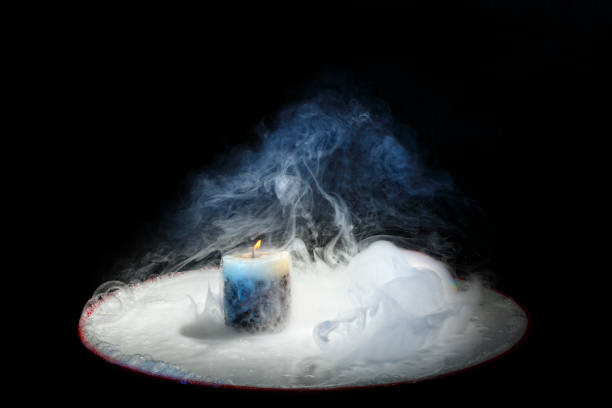 istock Beautiful candle with fire and smoke on a black background. 1164174760