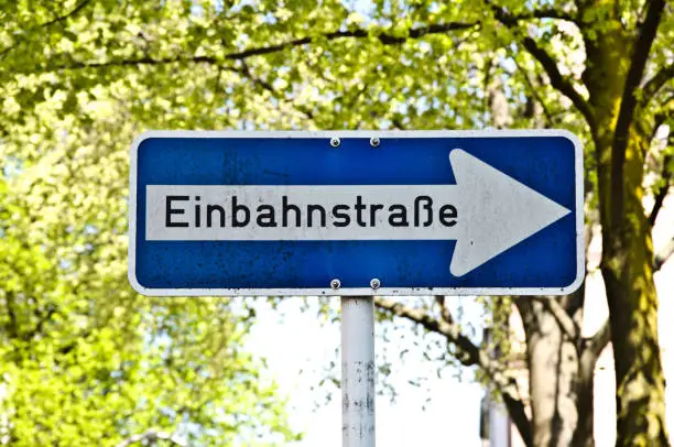 A weathered and dirty Einbahnstrasse (one-way street) sign