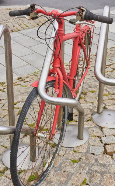 istock red bicycle parked chained on street 1164176661