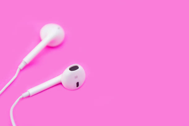 istock White earphones on pink background with copy space and clipping path. Flat lay. Top view. 1164180681