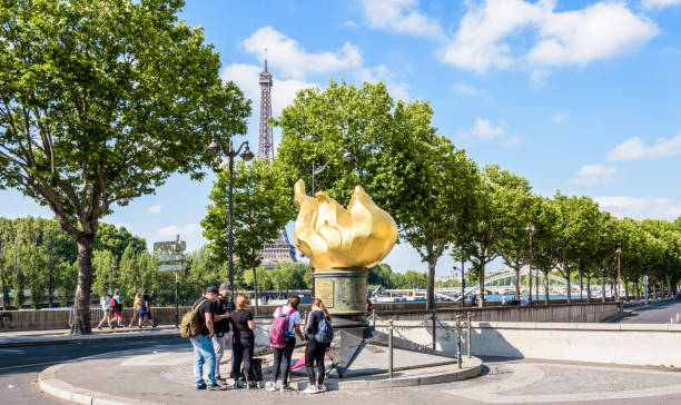 The Flame of Liberty in Paris, France, became a memorial to Princess Diana who died in the tunnel beneath. Paris, France - July 15, 2019: Tourists standing in front of the Flame of Liberty, a replica of the Statue of Liberty's flame, which became a memorial to Princess Diana who died in the tunnel beneath. princess of wales stock pictures, royalty-free photos & images