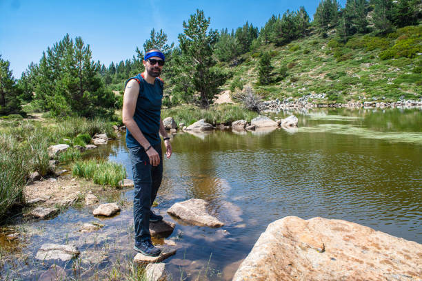 istock young man walks on rock in a mountain lake 1164181093