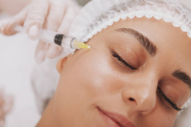 Beautiful young woman getting facial skincare treatment Cropped shot of a beautiful woman getting rejuvenating facial injections at cosmetology clinic. Professional beautician doing hyaluronic acid injections into female patient face. Youth, skincare concept corrective action stock pictures, royalty-free photos & images