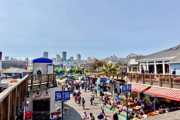 Fishermans Wharf Pier 39 area in San Francisco, California San Francisco, CA - August 25, 2018: High angle scenic view of a very busy Fishermans Wharf, Pier 39 area and the San Francisco Skyline on a clear summer day fishermans wharf san francisco photos stock pictures, royalty-free photos & images
