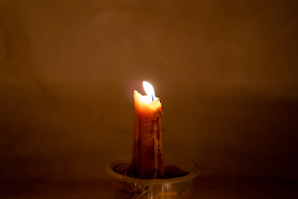 istock Fire burning and glowing candle on dark background 1164186104