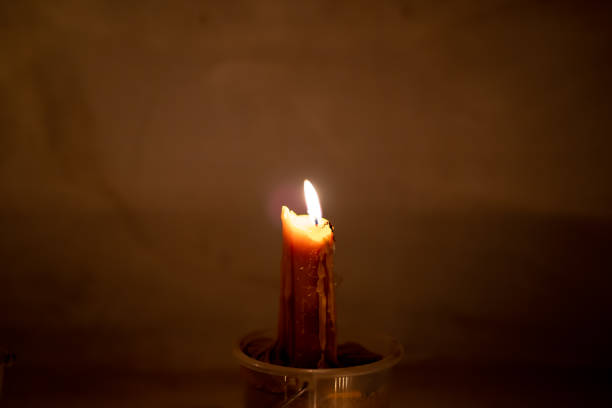 istock Fire burning and glowing candle on dark background 1164186145