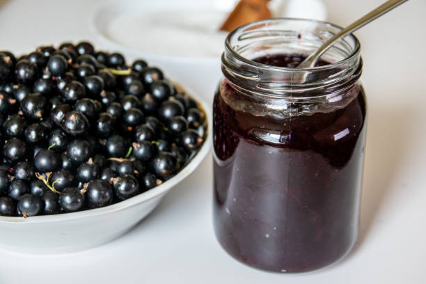 istock Black Currant Jam close-up. Blackcurrant berries in a bowl in the kitchen 1164189771