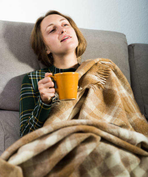 istock Woman resting on sofa with tea 1164195036