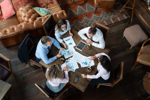 istock Business group at a hotel lounge in a meeting using documents and tablets while talking 1164197032