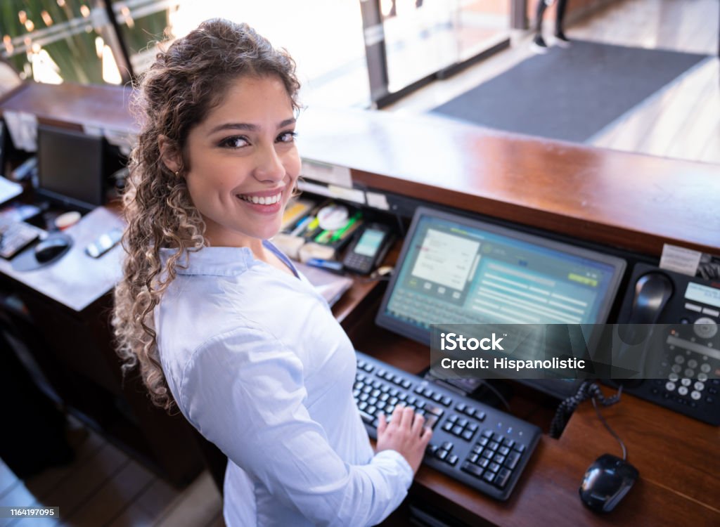 Receptionist Screen Friendly Latin American Hotel Receptionist Working On Computer Facing ...