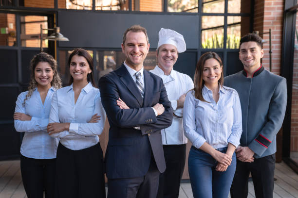 Cheerful latin american team of hotel staff all facing camera smiling Cheerful latin american team of hotel staff all facing camera smiling  - Business concepts bellhop photos stock pictures, royalty-free photos & images