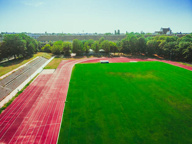istock stadium with green grass and red running line 1164197174