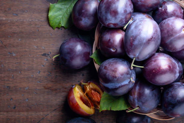 istock Ripe juicy plums on a old wooden table. 1164197190