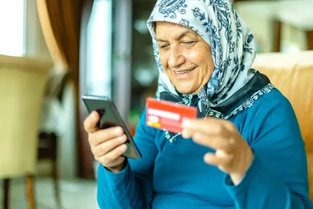Seniorwoman shopping online  with smart phone at home