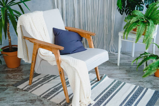 istock Soft chair with wooden armrests in cozy minimal interrier 1164198253