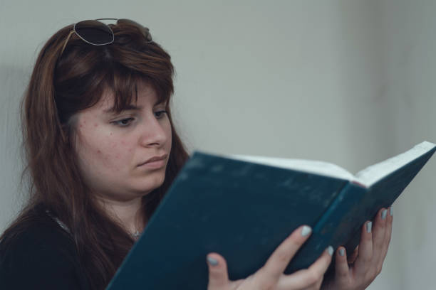 istock Portrait of woman reading a book 1164201285