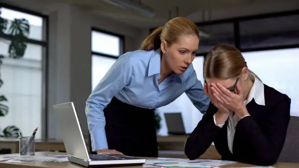 Photo of Boss shouting at frustrated employee, bullying and emotional abuse at work