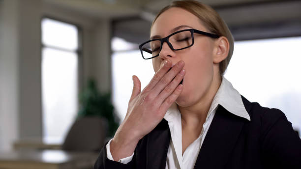 istock Businesswoman yawning while working at boring project, exhausted of overwork 1164203093