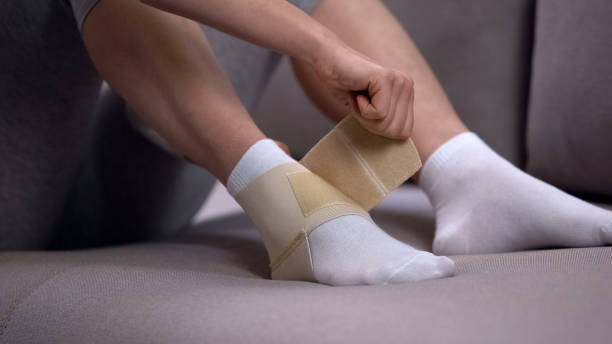 istock Woman fixing two-strap ankle wrap in proper position, sprained joint, healthcare 1164203136