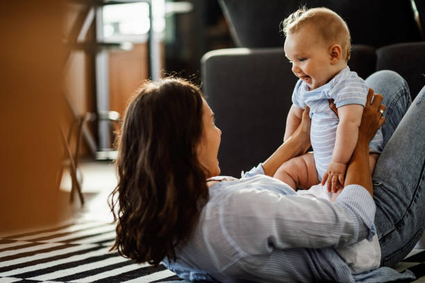 istock Cute baby having fun with mother at home. 1164203146