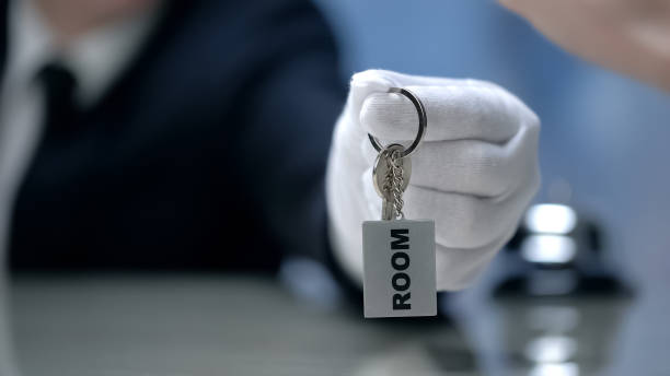 istock Receptionist giving room keys to client, quality service at hotel, check-in 1164204411