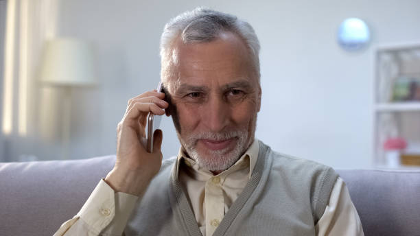 istock Glad pensioner talking on phone with close relatives, cheap mobile provider 1164204478