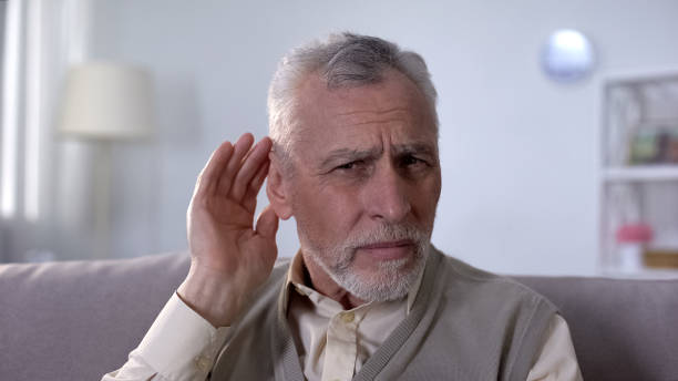 istock Confused pensioner trying to hear conversation, problem of deafness in old age 1164204600