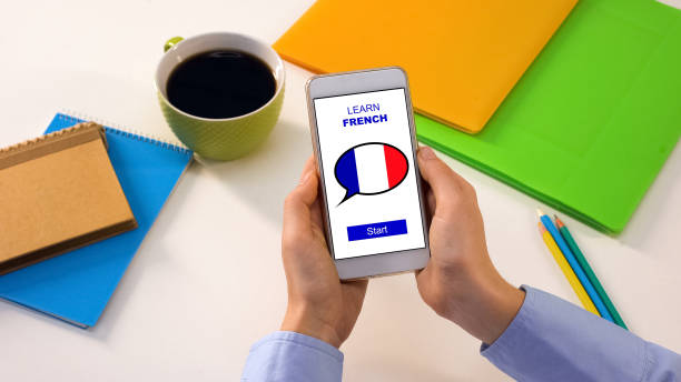 istock Person showing smartphone with learn French app, foreign language education 1164205070