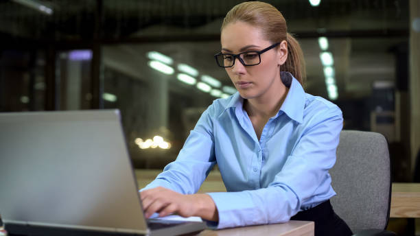 istock Serious employee working on laptop, career and employment concept, night shift 1164205143