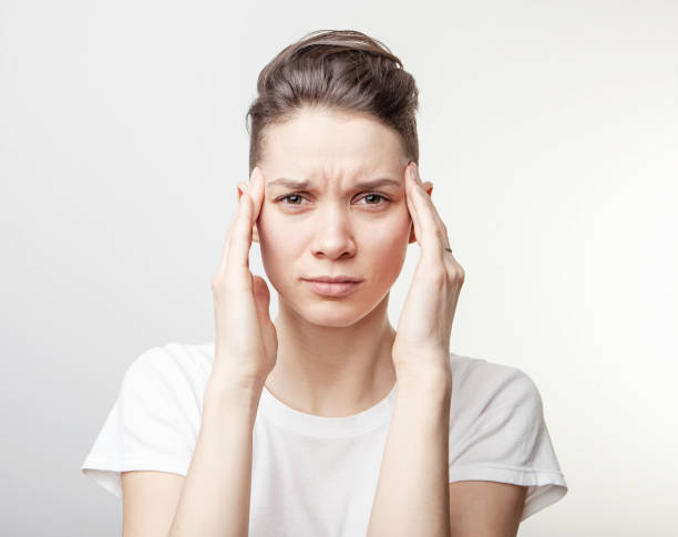 istock Young beautiful woman has headache, isolated on gray background. 1164207518