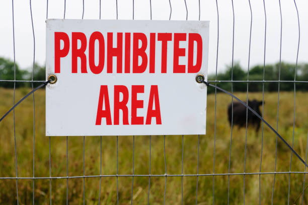 istock Sign on a fence beside a field 