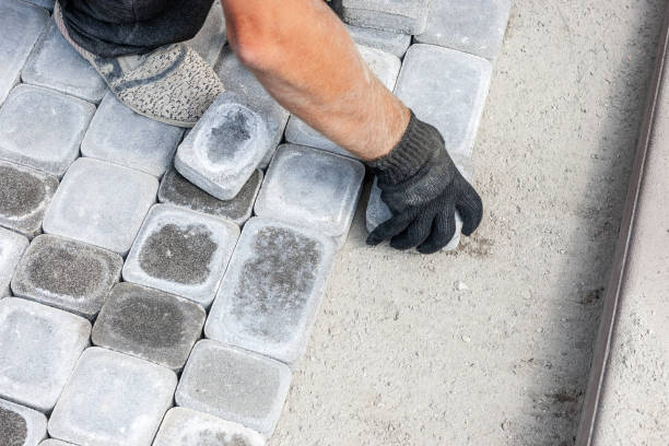 worker install new bricks or slab block to pathway. paving tiles for road repairs. stock photo