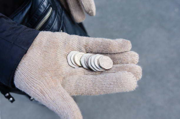 человек в шерстяной перчатке держит несколько монет великобритании - twenty pence coin стоковые фото и изображения