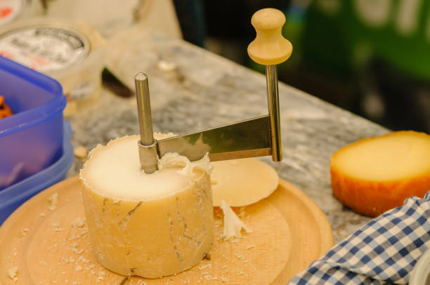 un rallador de queso rotativo sobre un queso de oveja redondo. - wash stand fotografías e imágenes de stock