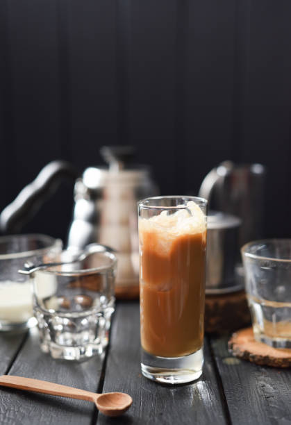 istock Iced coffee with cream in tall glass on black background copy space 1164210923