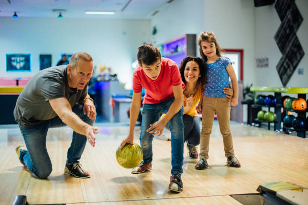 istock Boy bowling with parents and sister 1164212898