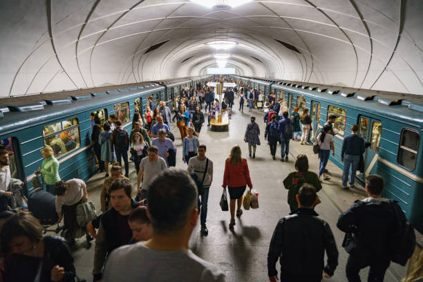 Moscow, Russia, April 25th 2019: Commuters in Moscow metro station. Stain glass panels form the central theme for this station opened in 1952