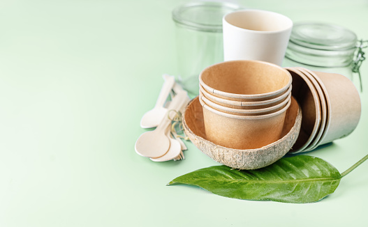 Eco tableware. Paper and bamboo cups, glasware, coconut cup, cotton net bag and wooden cutlery. Copy space