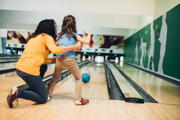 madre e hija jugando a los bolos - bowling holding bowling ball hobbies fotografías e imágenes de stock