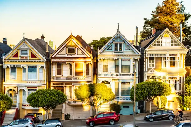 Row of charming colored Victorian style homes on the incline of the hills of San Francisco city, California. Front exterior view of beautiful houses. Modern architecture with vintage design appeal.